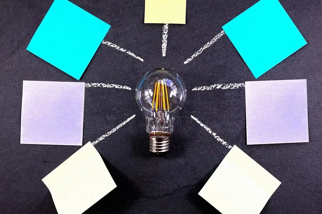 Light bulb surrounded by coloured sticky notes