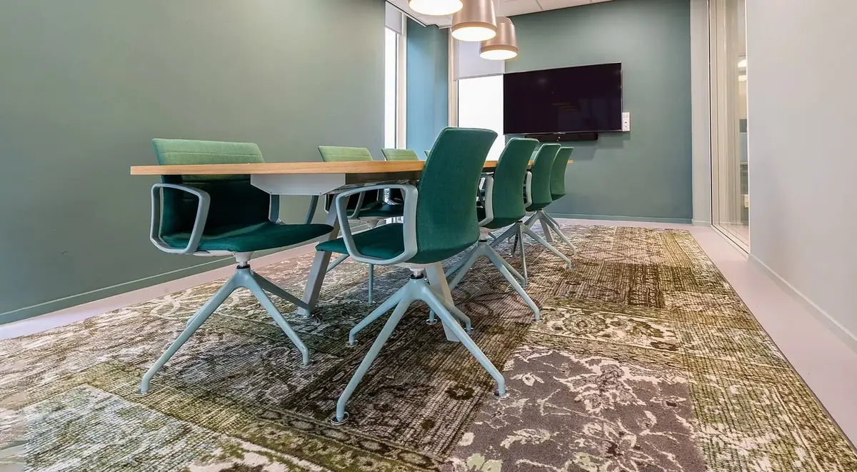 Meeting room with a wooden table and green chairs