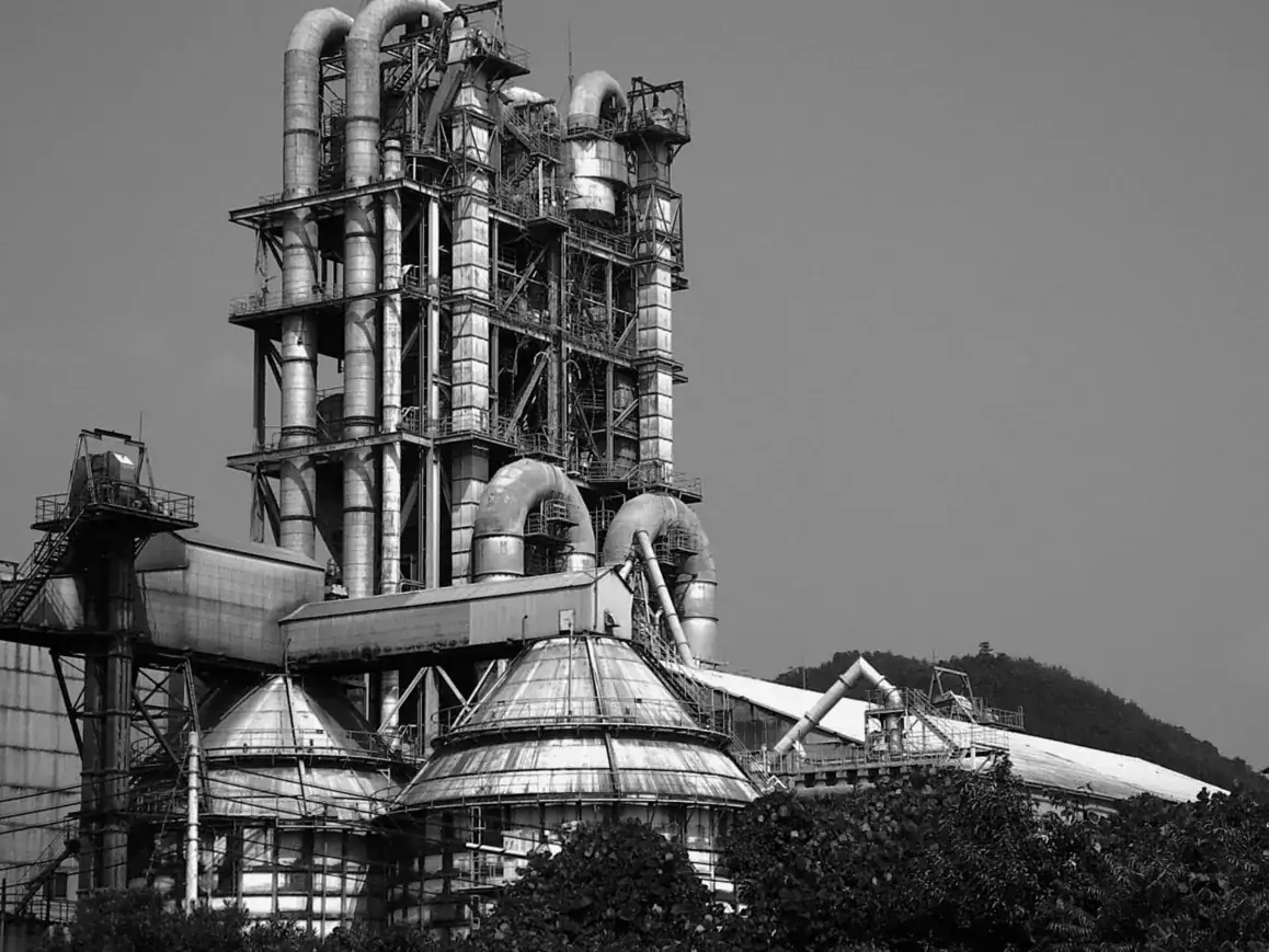Black-and-white photograph of an industrial plant with tall processing towers