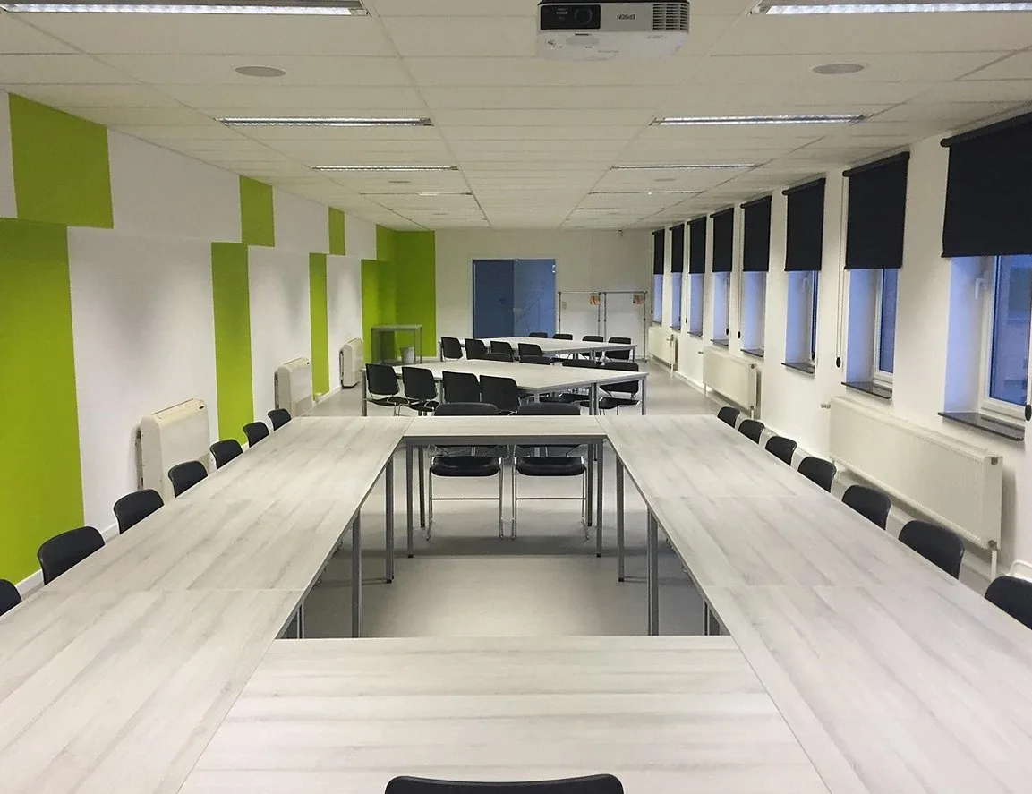 Long meeting table in a bright, empty conference room